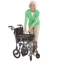 Load image into Gallery viewer, Introducing the Motion Healthcare Magnelite Transit Wheelchair, a lightweight and versatile mobility solution for indoor and outdoor use. Its folding aluminum frame ensures easy storage and transportation, while the magnesium alloy construction offers durability and style. Features include cushioned seating, folding armrests, quick-release rear wheels, and attendant brakes for safety and convenience. Experience newfound comfort and independence with the Motion Healthcare Magnelite Transit Wheelchair.